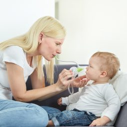 A woman clearing her son's nose with the help of the Nosiboo Eco Manual Nasal Aspirator
